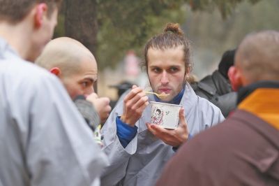 帮忙施粥后，“洋弟子”们也一起品尝美食。