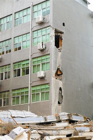 大楼倒塌时，砸坏了一旁的另一栋建筑。