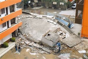 整个楼体坍塌成一堆废墟，砖砾、水泥块等混杂在一起。