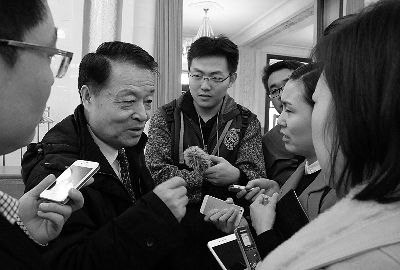 3月12日上午，十二届全国人大三次会议全体会议后，交通运输部部长杨传堂被记者“围堵”，回答出租车管理、专车等热点问题 摄/法制晚报记者 王南
