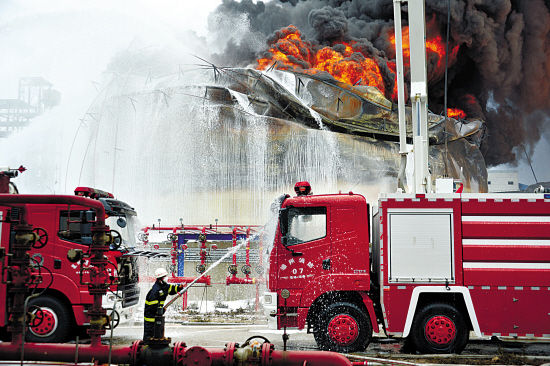 8日,救援人员用水枪给火场附近的消防车降温. 新华社发