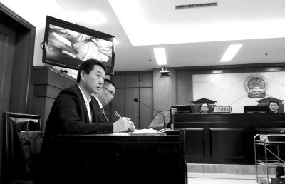 4月15日，在济南市市中区法院庭审现场，原告陈超（左）在观看被告提供的视频证据。新华社发