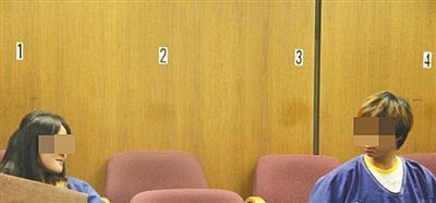 被告人翟某在法庭上跟另一名被告人张某眼神交流。