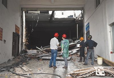 昨日，工作人员在鞋厂厂房倒塌事故现场。