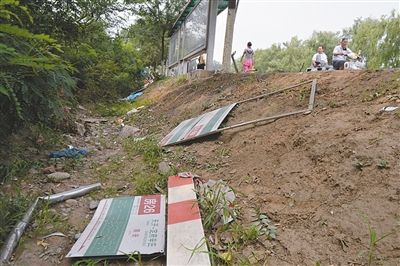 昨日，被撞倒的公交站牌散落在旁边。新京报记者 吴江 摄