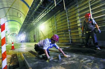 在地铁14号线大望路站，施工人员正在进行车站主体及与1号线换乘通道的内装修工作。 记者 孙戉 摄