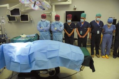 今年2月2日，一场捐献手术前医护人员为捐献者默哀，左四为器官捐献协调员吴平（资料图）。京华时报记者 陶冉 摄