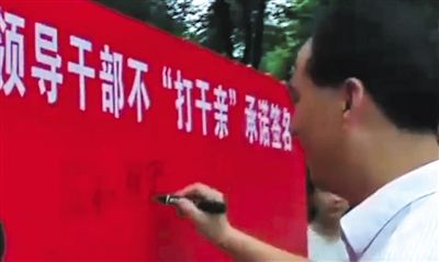 县领导带头在不“打干亲”集体承诺活动现场签名。视频截图