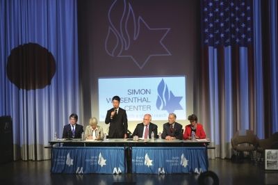 7月19日，在美国洛杉矶，日本三菱材料高管木村光站起来向美军战俘劳工代表詹姆斯·墨菲(右二)道歉。新华社发