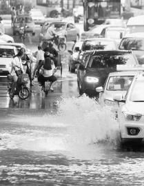 雨后马路积水较深，骑行的市民不得不调转车身驶离此处 新文化记者 吴廷 摄 