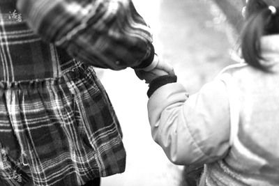 两名“失母”姐妹拉着手走在路上。