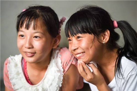 刘思圆（左）在家中和前来采访的记者交流（7月27日摄）。新华社记者 张端 摄 