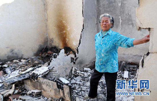 死者张纪民的亲戚在被烧毁的房屋内哭泣 新华社记者周科摄