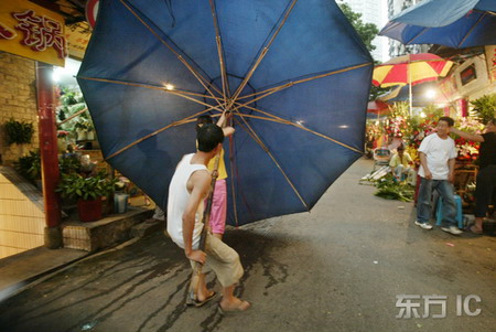 图文:摊贩的雨伞被大风吹倒