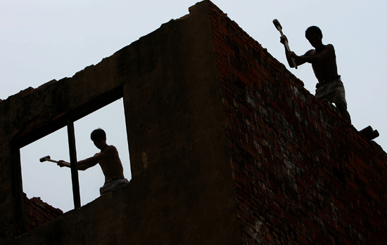 图文:农民工在挥动榔头拆除废旧房屋