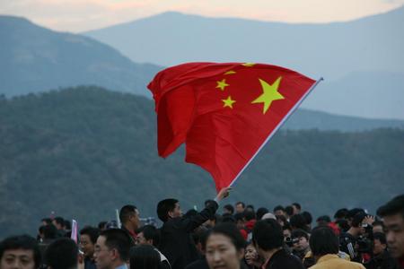 图文一位游客在人群中挥舞国旗