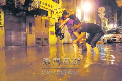 男子背起女士涉水过路。来源：《澳门日报》