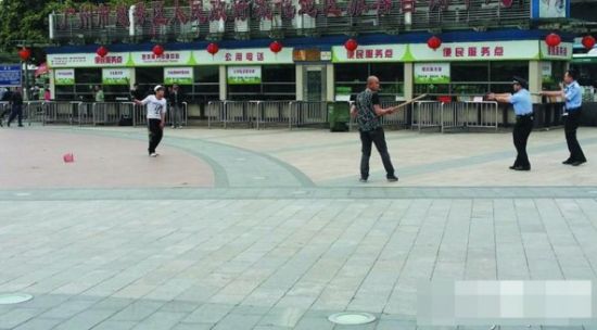 凶徒与警察和见义勇为的“扁担哥”对峙。(资料图片)