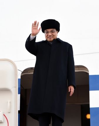 李克强一边走下舷梯一边向大家挥手致意。