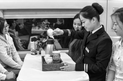 茶艺师在餐车内为旅客泡茶。