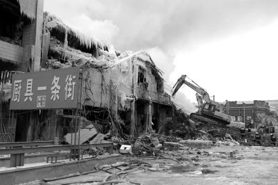 昨天下午，挖掘机清除的废墟外部仍挂着因救火结出的冰凌。京华时报记者谭青摄