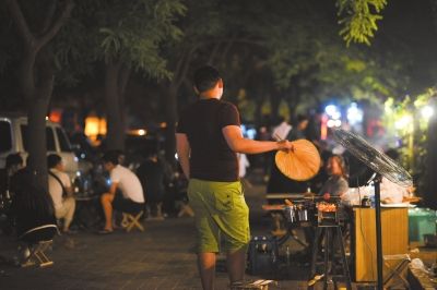 昨晚10时左右，左家庄地区居民楼附近的烧烤摊生意红火，烟雾缭绕。 京华时报记者 王苡萱摄