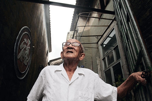 珠海唐家，92 岁的唐鸿光在唐绍仪故居侧墙“福”字前。（钟凡 摄）