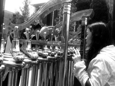 不能进校园，一位家长隔着伸缩门和孩子说话。