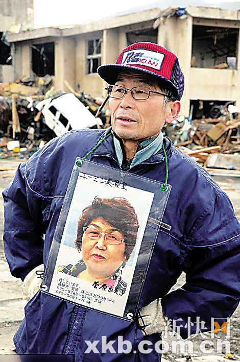 　　■在岩手县大槌町，菅原谦二把妻子照片挂在胸前，希望找到失踪的妻子。