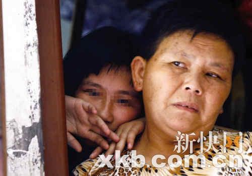 　　■飞飞躲在母亲的身后，表现沉默。