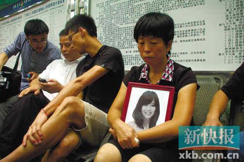 　　■死者张瑞灵的亲人抱着遗像在等待消息。