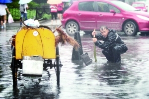 　　李成友用树枝通下水道。