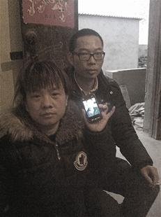 胡玖荣拿着存有儿子照片的手机