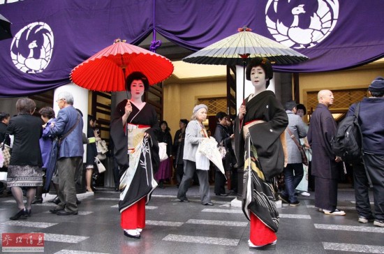 穿着日本服饰的艺妓站在东京的一家歌舞伎座前。位于日本东京银座的歌舞伎座重新开业。资料图片