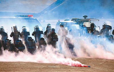 点击图片进入下一页参演警察在烟雾弹掩护下处置群体性事件.