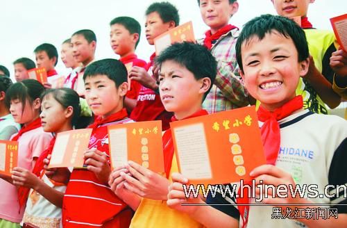 图为安达市永福希望小学毕业学生手拿统一颁发的毕业证.