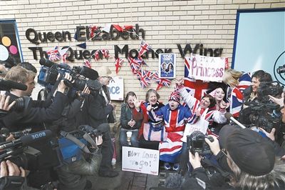 身上穿着英国米字旗图案外套的“王室粉丝团”激动地庆祝小公主诞生。