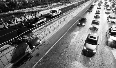 别克冲破护栏，半个车身悬半空，下面就是三环主路摄/法制晚报记者 郭谦