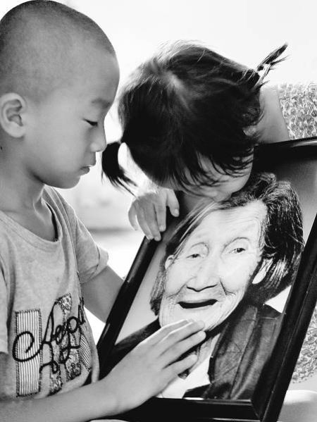 一个小女孩亲吻楼小英的遗像。陈少华摄