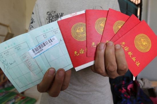 王展鹏向记者展示妻子王霞生前留下的献血证，“王红霞”是王霞以前用的名字 摄/深度记者王南