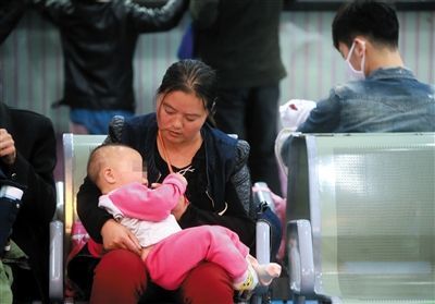 月23日，被扎针女婴在母亲怀中等待儿童医院会诊结果。新京报记者 浦峰 摄