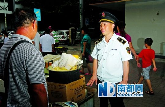 花都区城管执法队员陆良光在与街头小贩交谈