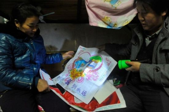 图图为12月28日，广东中山，女儿已身亡，妈妈拿着手机，手机照片就是18岁少女丁双琴。 摄影：吴进