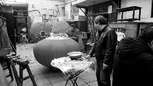 在这排封顶起来的小平房里，王师傅正在专心地糊灯笼。