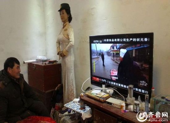 朱之文坐在自己的新家中，看着电视上的自己。