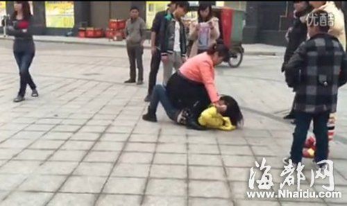 红衣女子揪着一名黄衣女子的头发，高声谩骂(视频截图)