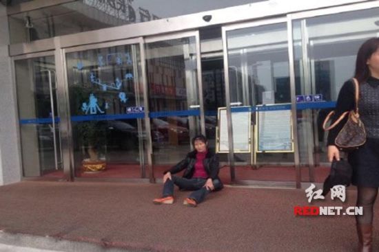 得不到79万的拆迁款，朱金莲瘫坐在银行门口，希望钱能退回来。