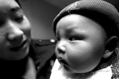 明明被警方成功解救，孩子在女民警的怀里一直没有哭闹。京华时报记者欧阳晓菲摄▲