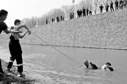 　　于先生（右）和消防战士（正在水中潜泳）合力救援坠河老人 消防供图