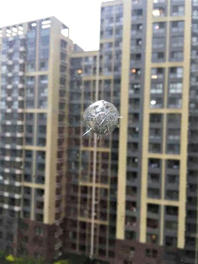 因邻楼男孩偷买气枪射击，朝阳光熙家园一住户窗玻璃留下弹痕。 新京报记者 王大鹏 摄
